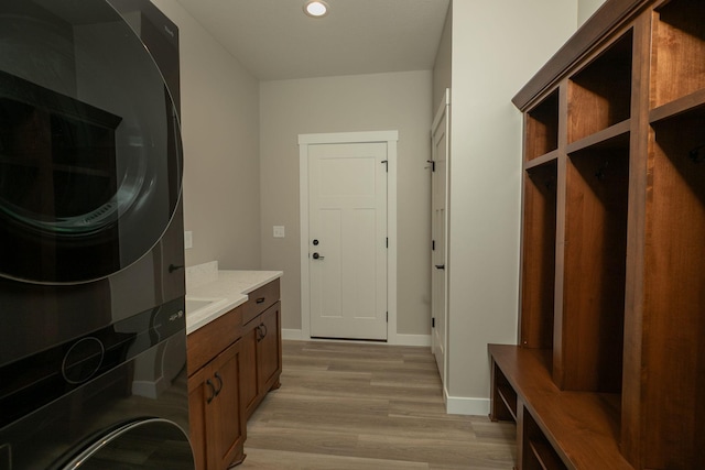 1202 15th St NE, Kasson, MN 55944 - washroom with stacked washer / dryer, cabinet space, light wood-type flooring, recessed lighting, and baseboards