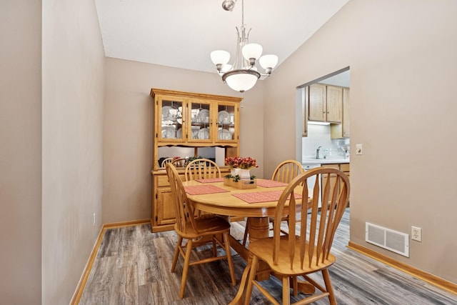 3726 Gershwin Ln N, Oakdale, MN 55128 - dining room featuring a chandelier, light wood-style floors, and vaulted ceiling