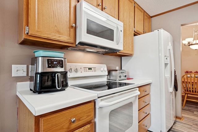 3726 Gershwin Ln N, Oakdale, MN 55128 - kitchen with white appliances, crown molding, light countertops, light wood finished floors, and a chandelier