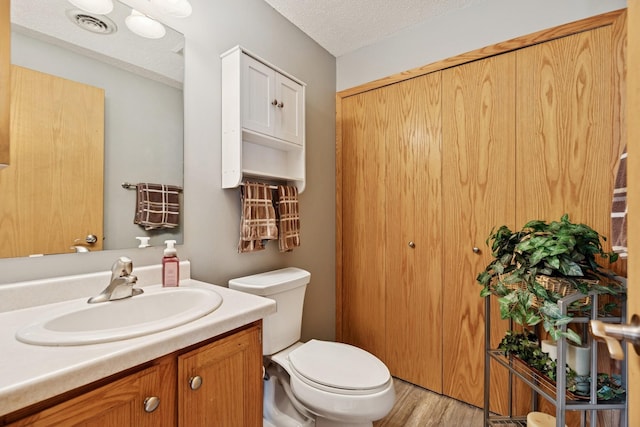 3726 Gershwin Ln N, Oakdale, MN 55128 - bathroom featuring vanity, wood finished floors, and a textured ceiling