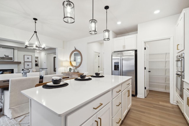 10625 29th St NE, Saint Michael, MN 55376 - kitchen with stainless steel fridge with ice dispenser, a center island, light countertops, white cabinetry, and light wood finished floors