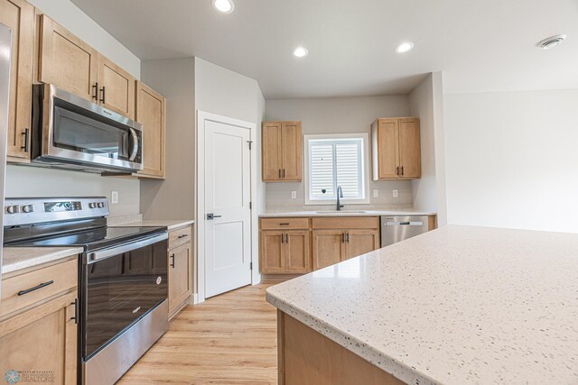 6614 68th St S, Horace, ND 58047 - kitchen with stainless steel appliances, light wood-style floors, light brown cabinets, recessed lighting, and light stone counters