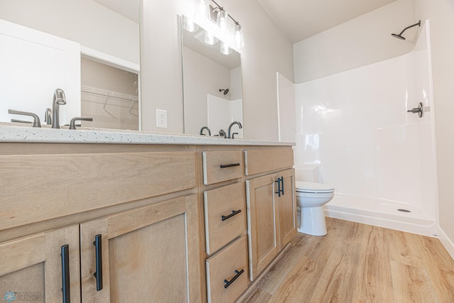 6614 68th St S, Horace, ND 58047 - bathroom with wood finished floors, double vanity, a shower, and a walk in closet