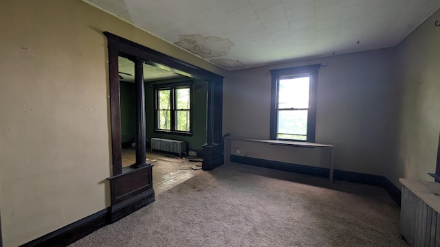 307 10th St S, Wheaton, MN 56296 - unfurnished room with radiator, carpet floors, and a wood stove
