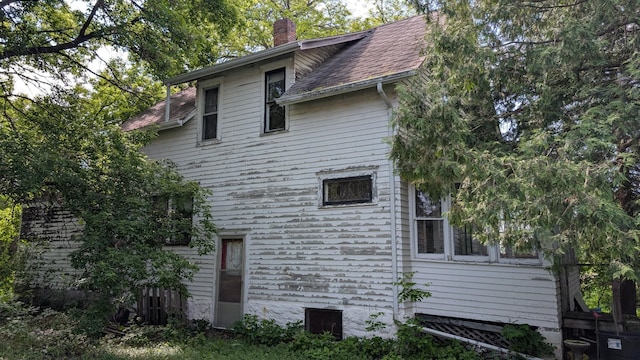 307 10th St S, Wheaton, MN 56296 - view of property exterior featuring a chimney and roof with shingles