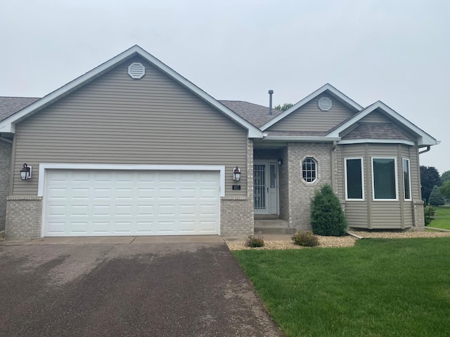 917 133rd Ln NE, Ham Lake, MN 55304 - ranch-style home with driveway, brick siding, a front lawn, roof with shingles, and an attached garage
