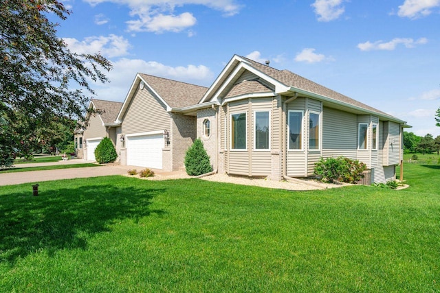 917 133rd Ln NE, Ham Lake, MN 55304 - view of front of home featuring a garage, a front yard, concrete driveway, roof with shingles, and brick siding