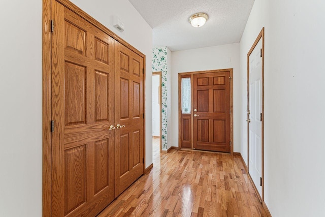 917 133rd Ln NE, Ham Lake, MN 55304 - entrance foyer featuring light wood-style floors, a textured ceiling, and baseboards
