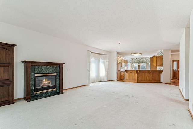 917 133rd Ln NE, Ham Lake, MN 55304 - unfurnished living room with a chandelier, a premium fireplace, light colored carpet, and baseboards