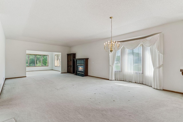 917 133rd Ln NE, Ham Lake, MN 55304 - unfurnished living room featuring a fireplace with flush hearth, a chandelier, carpet, a textured ceiling, and baseboards