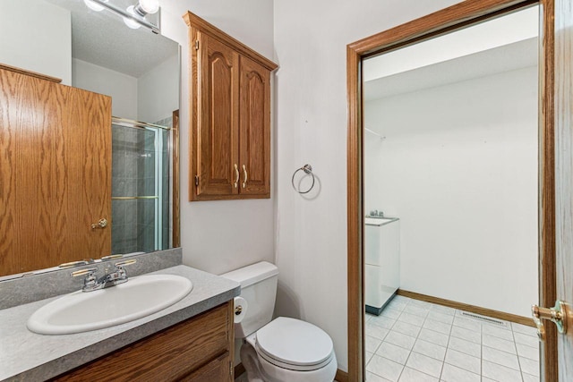 917 133rd Ln NE, Ham Lake, MN 55304 - bathroom with toilet, vanity, an enclosed shower, and tile patterned floors