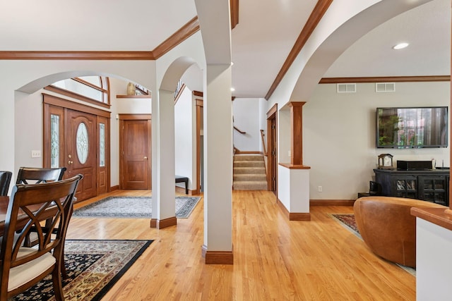 2906 Butternut Dr, Chaska, MN 55318 - foyer entrance featuring ornamental molding, arched walkways, light wood-style flooring, stairway, and recessed lighting