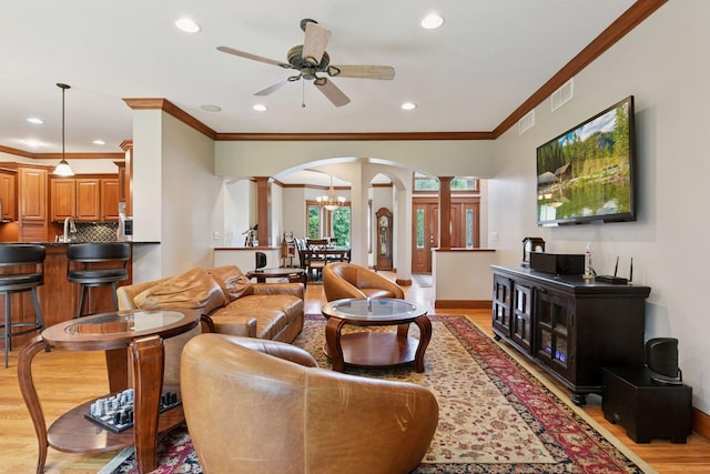 2906 Butternut Dr, Chaska, MN 55318 - living room with ornate columns, arched walkways, light wood-type flooring, a ceiling fan, and ornamental molding