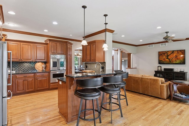 2906 Butternut Dr, Chaska, MN 55318 - kitchen featuring appliances with stainless steel finishes, open floor plan, arched walkways, a peninsula, and ceiling fan