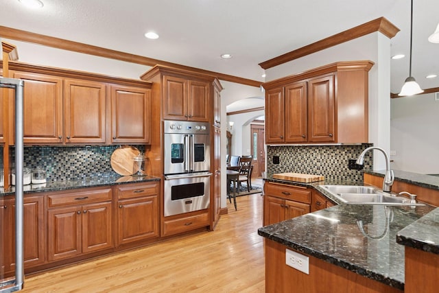 2906 Butternut Dr, Chaska, MN 55318 - kitchen featuring double oven, arched walkways, brown cabinets, backsplash, and recessed lighting