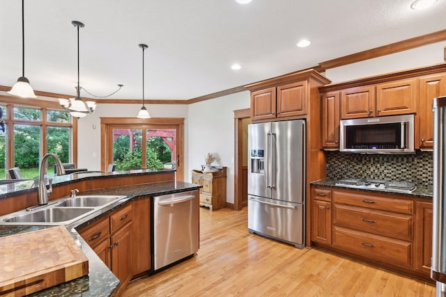 2906 Butternut Dr, Chaska, MN 55318 - kitchen featuring stainless steel appliances, brown cabinets, light wood-style floors, pendant lighting, and backsplash
