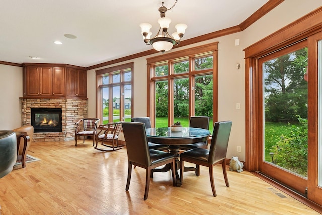 2906 Butternut Dr, Chaska, MN 55318 - dining room with ornamental molding, plenty of natural light, a fireplace, light wood finished floors, and a chandelier