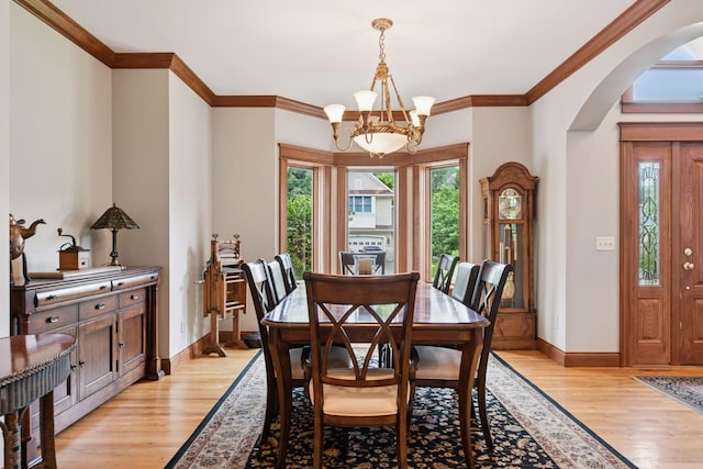 2906 Butternut Dr, Chaska, MN 55318 - dining space featuring arched walkways, a chandelier, light wood-type flooring, and crown molding