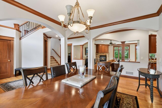 2906 Butternut Dr, Chaska, MN 55318 - dining room featuring stairs, light wood-style flooring, a fireplace, a ceiling fan, and ornamental molding