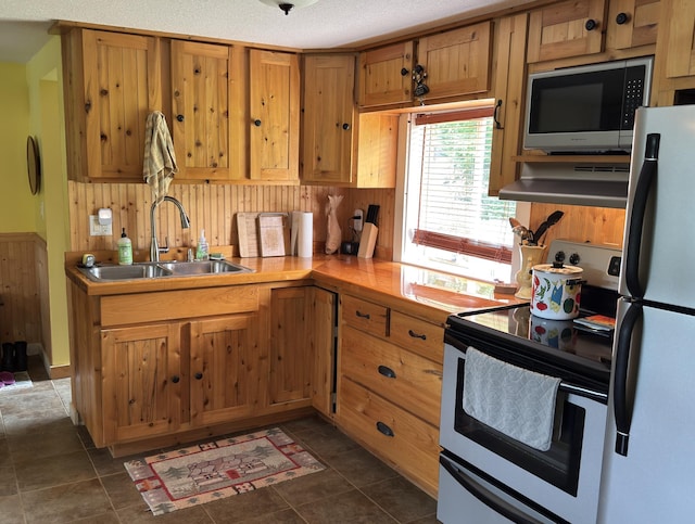 17251 State Highway 6, Deerwood, MN 56444 - kitchen featuring stainless steel appliances, under cabinet range hood, light countertops, wooden walls, and dark tile patterned flooring