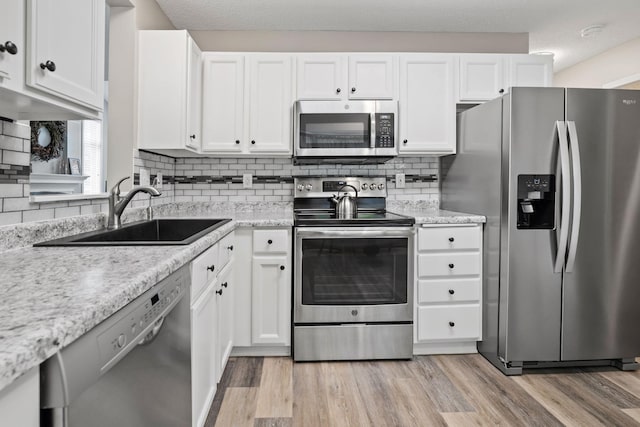 4345 Merrimac Ln N Unit 7, Plymouth, MN 55446 - kitchen featuring appliances with stainless steel finishes, a sink, white cabinets, and light wood finished floors