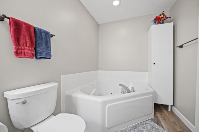 4345 Merrimac Ln N Unit 7, Plymouth, MN 55446 - bathroom with wood finished floors, a jetted tub, toilet, baseboards, and a textured ceiling