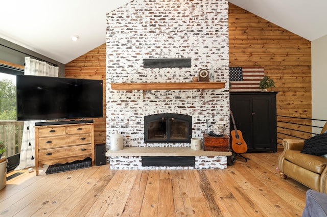 3250 Wild Turkey Ln, Red Wing, MN 55066 - living room with lofted ceiling, wooden walls, a tile fireplace, and hardwood / wood-style flooring