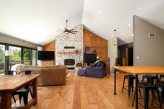 3250 Wild Turkey Ln, Red Wing, MN 55066 - living room with wood walls, a ceiling fan, high vaulted ceiling, light wood-type flooring, and a tile fireplace