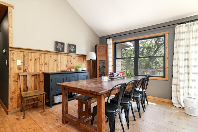 3250 Wild Turkey Ln, Red Wing, MN 55066 - dining room featuring light wood-type flooring, vaulted ceiling, wooden walls, and wainscoting