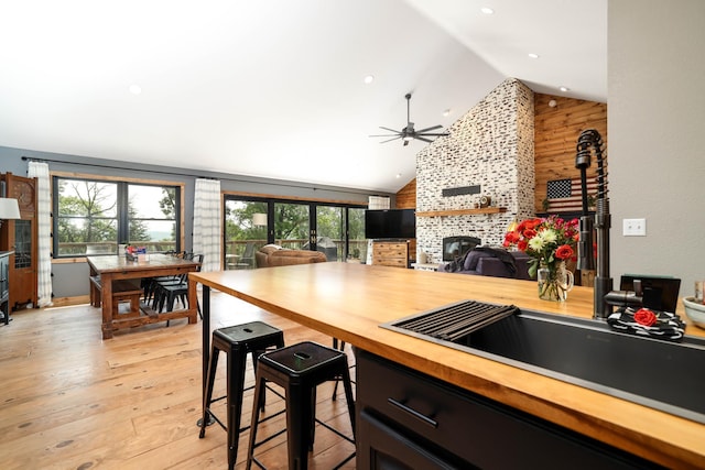 3250 Wild Turkey Ln, Red Wing, MN 55066 - kitchen with high vaulted ceiling, light wood-type flooring, a ceiling fan, butcher block countertops, and a fireplace