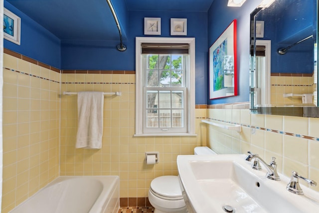 5718 13th Ave S, Minneapolis, MN 55417 - bathroom featuring a sink, tile walls, toilet,  shower combination, and a wainscoted wall