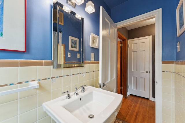 5718 13th Ave S, Minneapolis, MN 55417 - bathroom featuring a sink, tile walls, wood finished floors, and a wainscoted wall