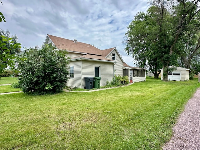 114 Thompson Ave, Rushmore, MN 56168 - view of home's exterior featuring a sunroom, an outdoor structure, a yard, and roof with shingles