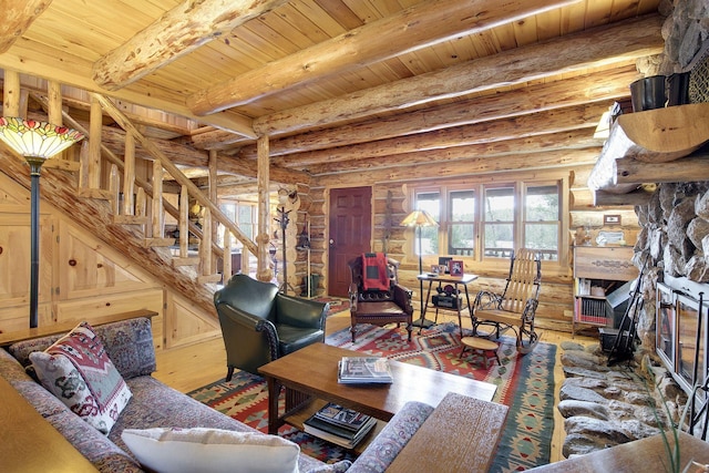 9453 Little Elbow Lk N, Cook, MN 55723 - living room with log walls, wood finished floors, a stone fireplace, wood ceiling with exposed beams, and stairs