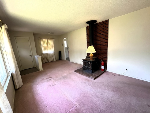 757 111th Ave NW, Coon Rapids, MN 55448 - living room featuring a wood stove, light carpet, a textured ceiling, and baseboards
