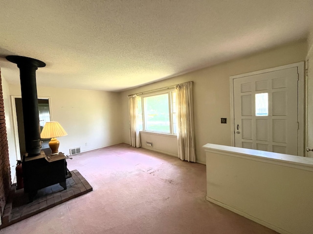 757 111th Ave NW, Coon Rapids, MN 55448 - entryway with a wood stove, light carpet, and a textured ceiling