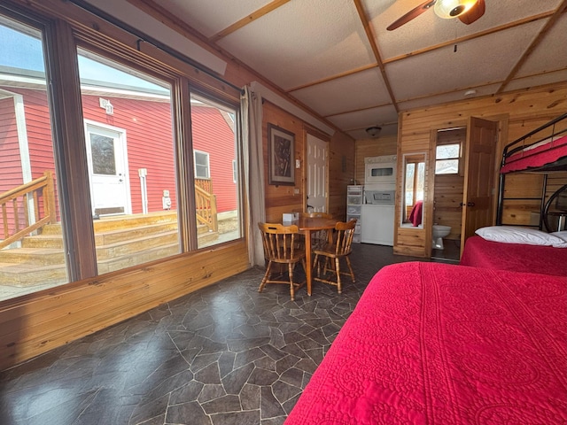 13150 Maple Circle Dr SE, Hudson Twp, MN 56334 - bedroom with wooden walls, stone floors, and washer / clothes dryer