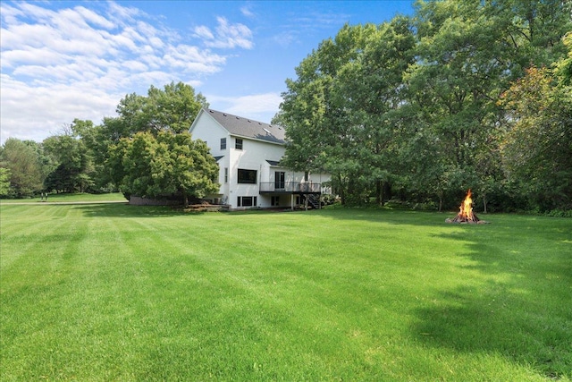 1848 141st Ln NE, Ham Lake, MN 55304 - view of green lawn with stairway, a deck, and an outdoor fire pit