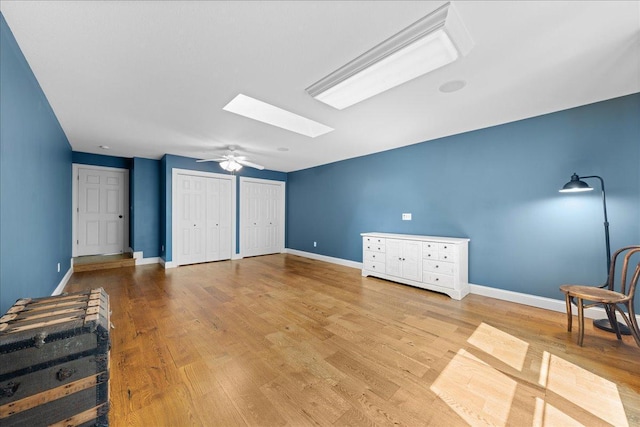 1848 141st Ln NE, Ham Lake, MN 55304 - unfurnished bedroom featuring a skylight, multiple closets, wood finished floors, and ceiling fan