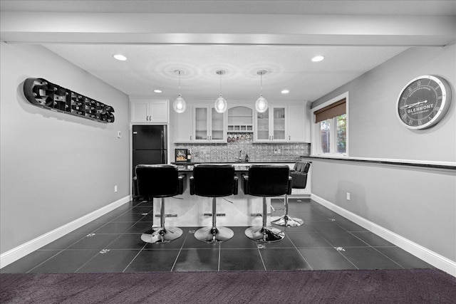 1848 141st Ln NE, Ham Lake, MN 55304 - kitchen featuring white cabinets, freestanding refrigerator, a center island, glass insert cabinets, and tasteful backsplash