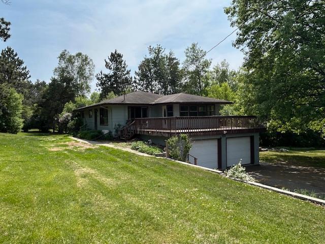 601 1st Ave, Grand Rapids, MN 55744 - view of front of property with a front yard, a deck, asphalt driveway, and a garage