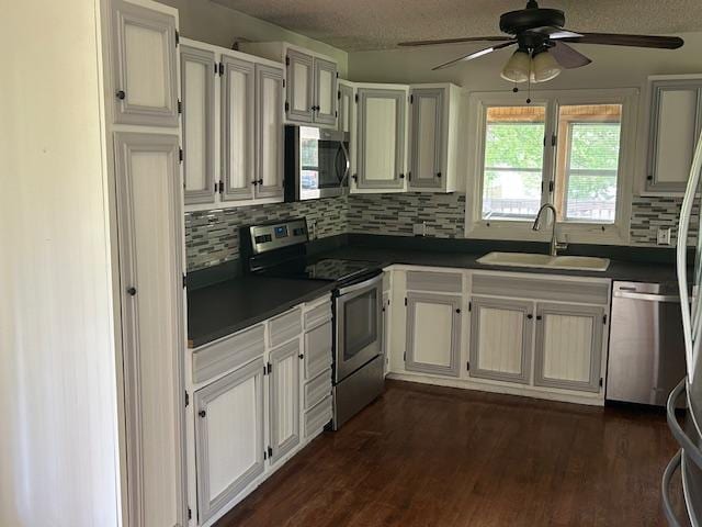 601 1st Ave, Grand Rapids, MN 55744 - kitchen featuring appliances with stainless steel finishes, a sink, dark countertops, backsplash, and a ceiling fan