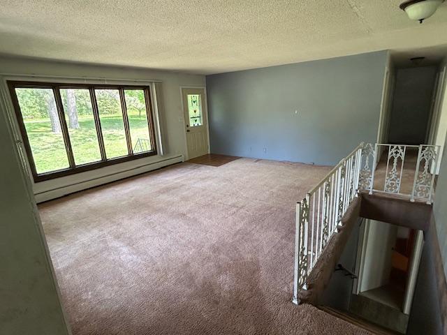 601 1st Ave, Grand Rapids, MN 55744 - unfurnished room with carpet floors, a baseboard heating unit, and a textured ceiling
