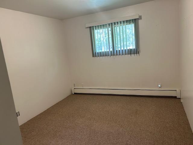 601 1st Ave, Grand Rapids, MN 55744 - carpeted spare room with a baseboard radiator