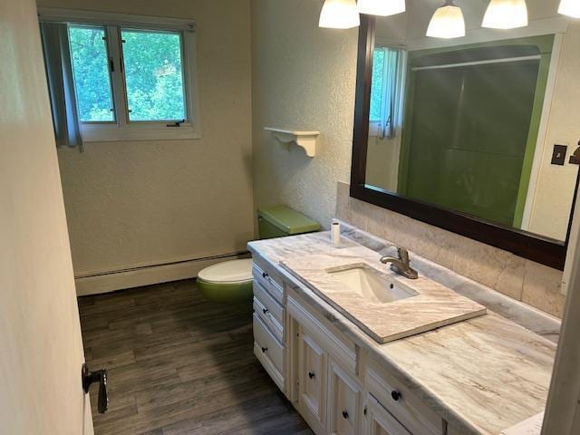 601 1st Ave, Grand Rapids, MN 55744 - full bathroom featuring a baseboard radiator, vanity, toilet, a stall shower, and a textured wall