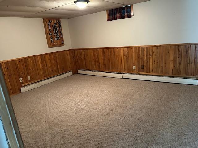 601 1st Ave, Grand Rapids, MN 55744 - finished below grade area with wooden walls, a wainscoted wall, a baseboard heating unit, a drop ceiling, and carpet