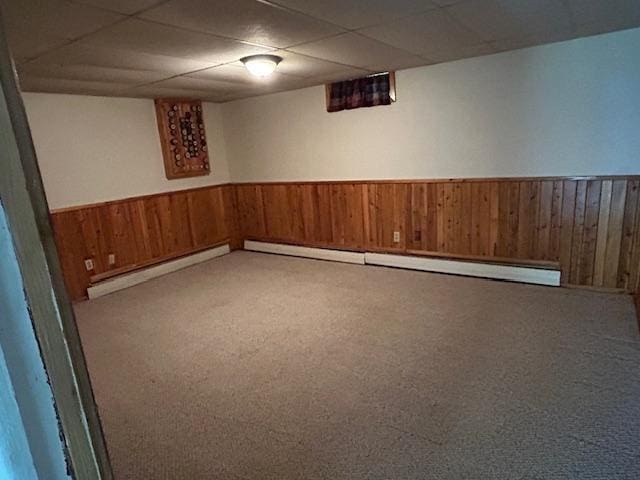 601 1st Ave, Grand Rapids, MN 55744 - finished below grade area featuring wood walls, baseboard heating, a wainscoted wall, carpet floors, and a paneled ceiling