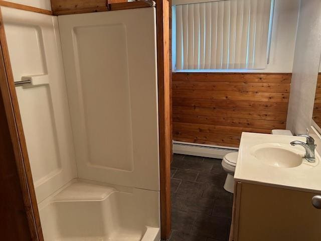 601 1st Ave, Grand Rapids, MN 55744 - bathroom featuring a baseboard heating unit, a stall shower, toilet, vanity, and wooden walls