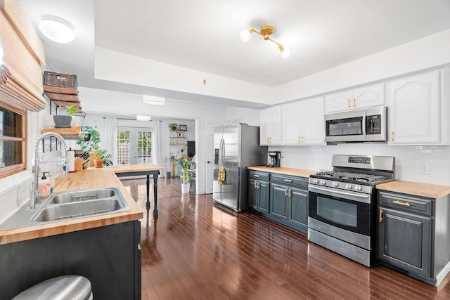 1714 5th St NE, Minneapolis, MN 55413 - kitchen featuring stainless steel appliances, butcher block countertops, a sink, and white cabinets