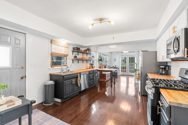 1714 5th St NE, Minneapolis, MN 55413 - kitchen with appliances with stainless steel finishes, wooden counters, a sink, dark wood-type flooring, and open shelves